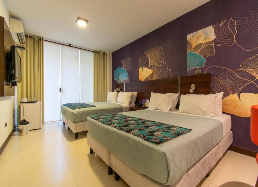 圣克鲁斯Mai Suites Apart Hotel的一间酒店客房,设有两张床和电视