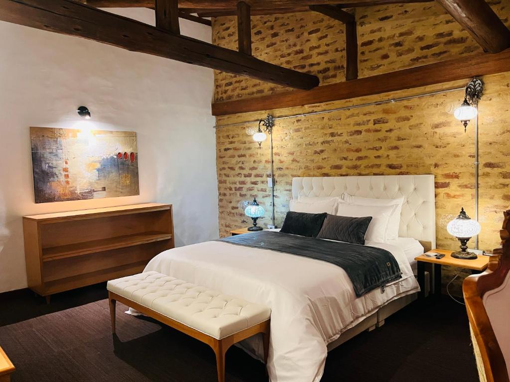 莱瓦镇Hotel Caney Villa de Leyva by MH的卧室配有白色的床和木墙