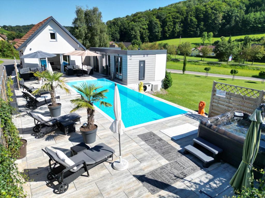 巴特格莱兴贝格Feriendomizil Schleich im Thermenland的一个带游泳池和小房子的后院