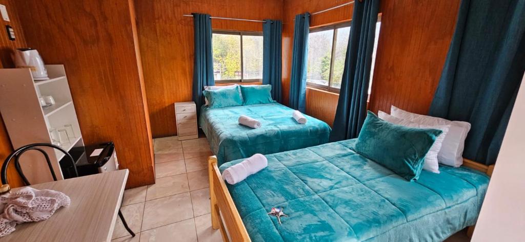 圣何塞德迈波El Tucan的一间卧室设有两张床、一张桌子和一个窗口