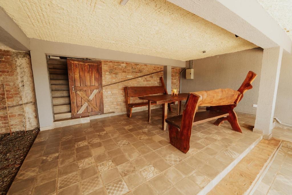 伊瓜苏港ISONDU Suites & Breakfast的配有桌子、椅子、桌子和窗户的房间