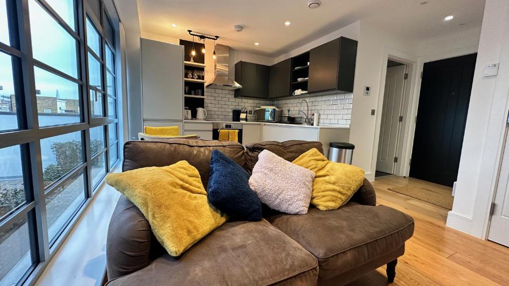 伦敦Modern & stylish 1 bedroom flat的客厅配有带枕头的棕色沙发