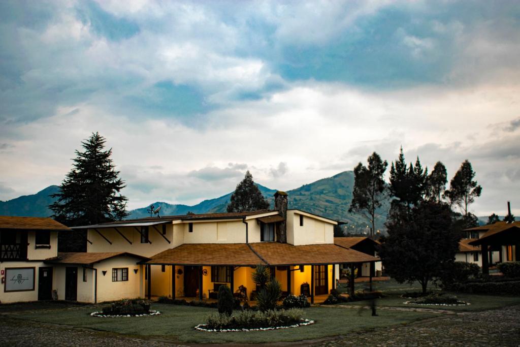 MachachiChuquiragua Lodge & Spa的一座大房子,背景是群山