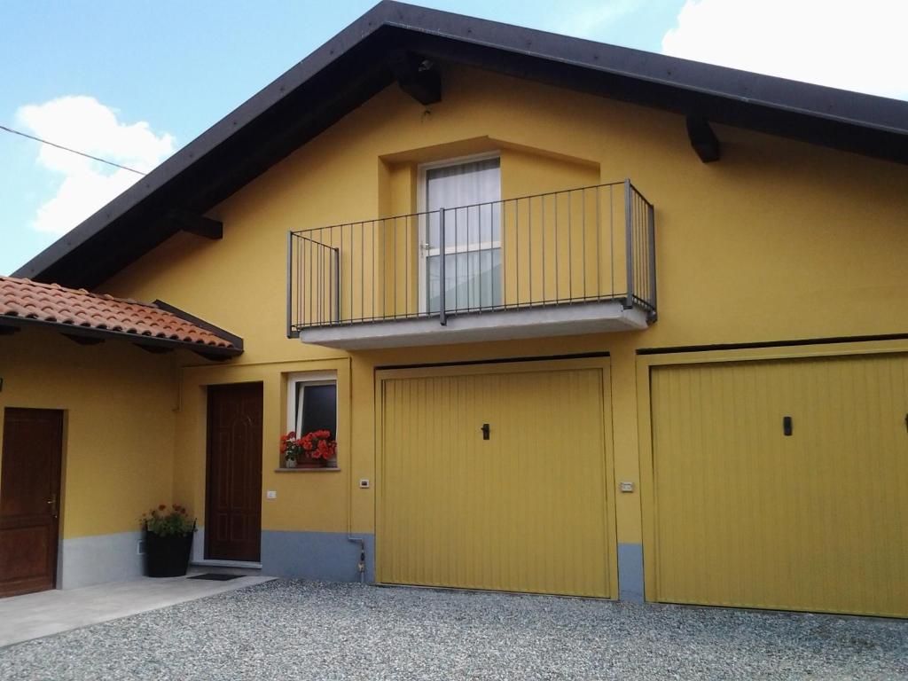 CandeloLa Mansarda Dell'Artista的黄色的房子,设有阳台和两个车库门