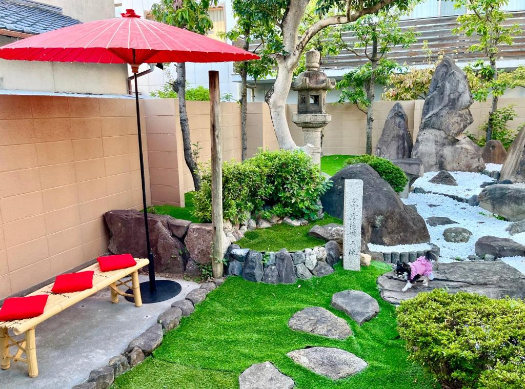 岸和田市民泊Murakami International的一个带长凳和遮阳伞的花园