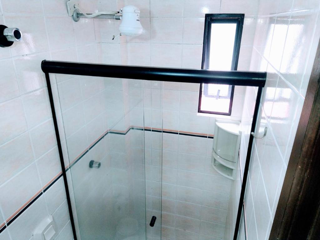 马蒂尼奥斯Triplex White em Caiobá-Matinhos-Pr a 200 mt do mar的浴室里设有玻璃门淋浴