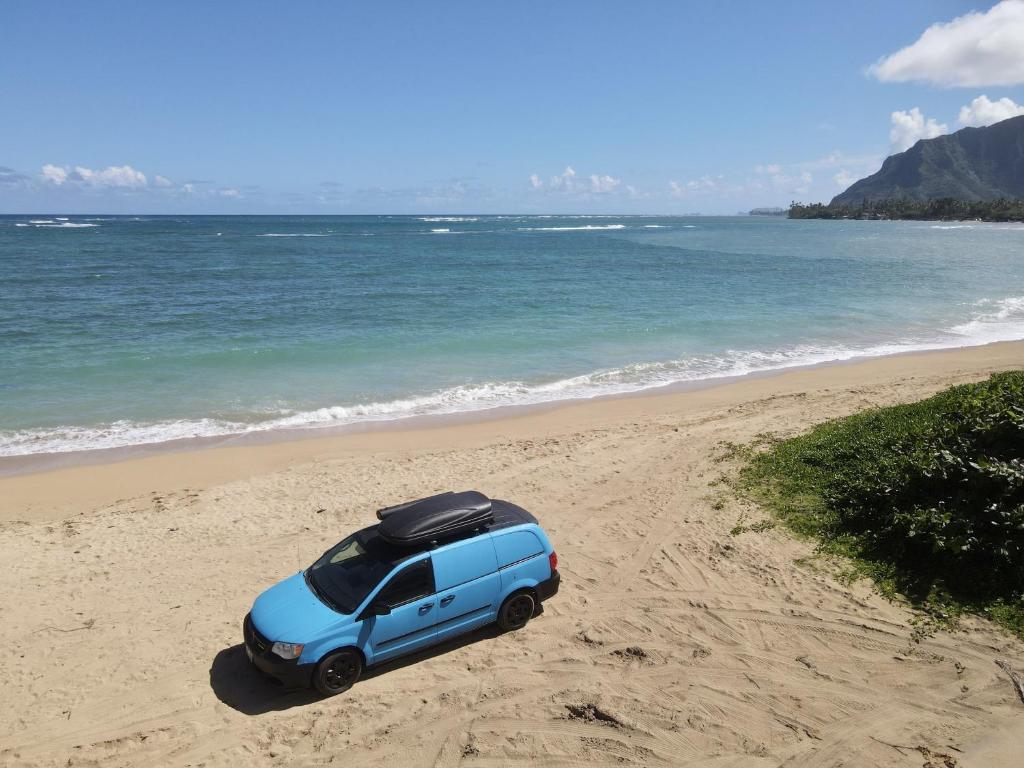 HauulaHW Campervan Rental NO CAMPGROUND的停在海边的蓝色汽车