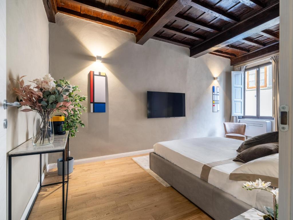 佛罗伦萨Santa Croce Luxury Suite - Dolcevita Holiday的卧室配有一张床,墙上配有电视。