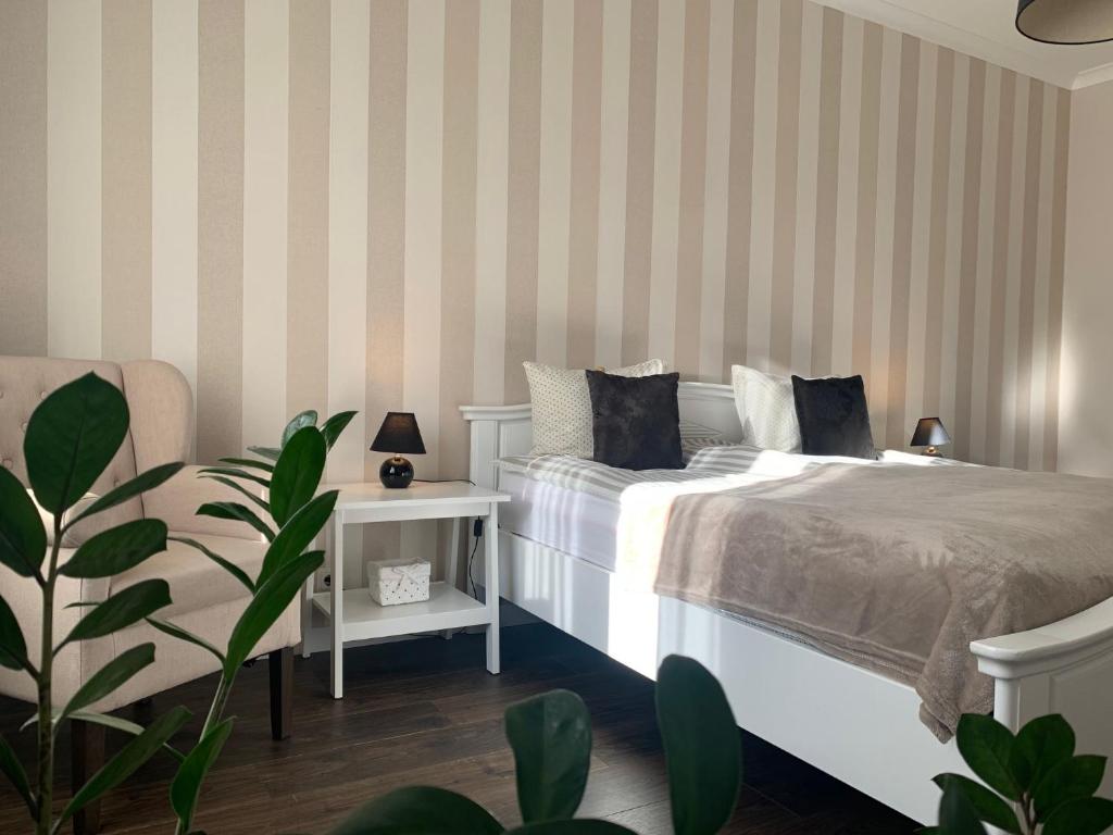尤尔马拉AquaGate Jurmala的卧室配有白色的床和条纹墙
