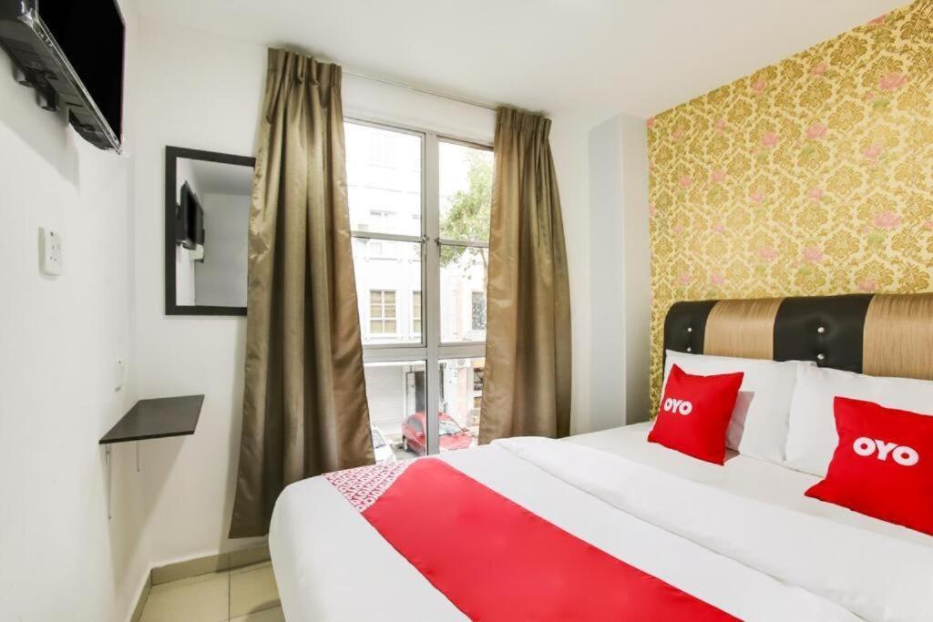 马六甲NS INN Hotel的酒店客房配有一张带红色枕头的大床