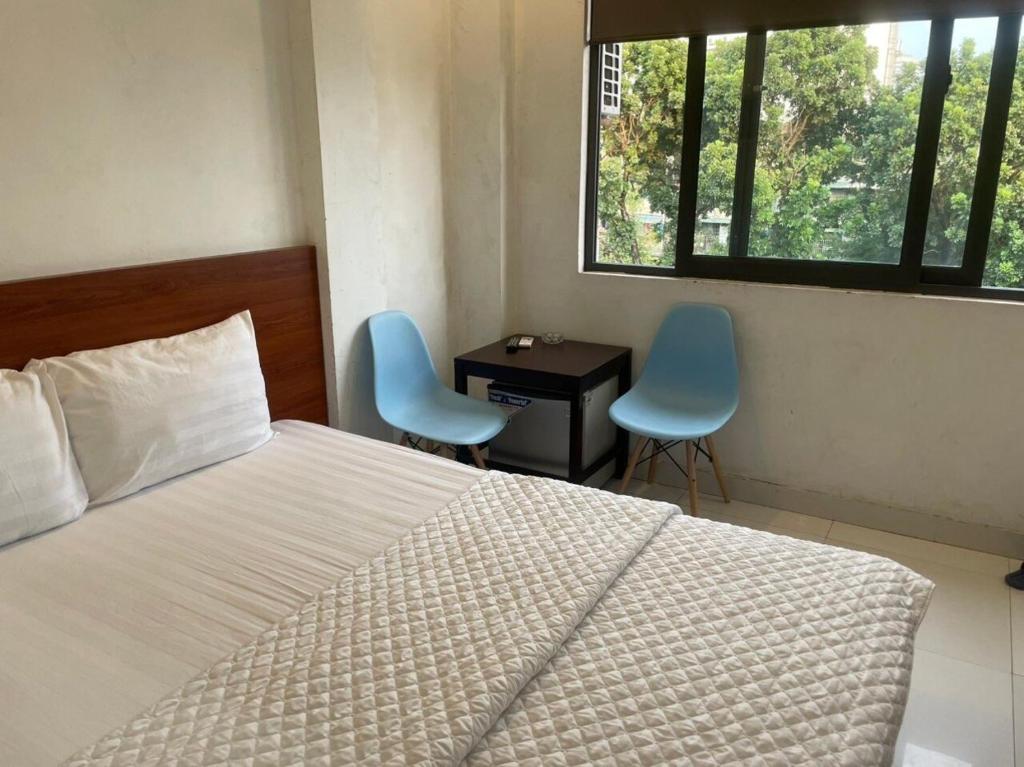 河内YÊN HÒA MOTEL的一间卧室配有一张床、两把椅子和一张书桌