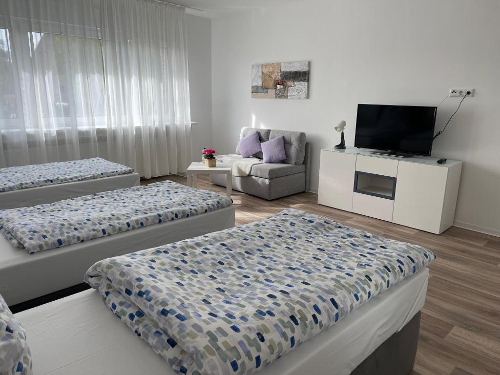 波尔塔韦斯特法利卡Monteurzimmer的一间带三张床和电视的客厅