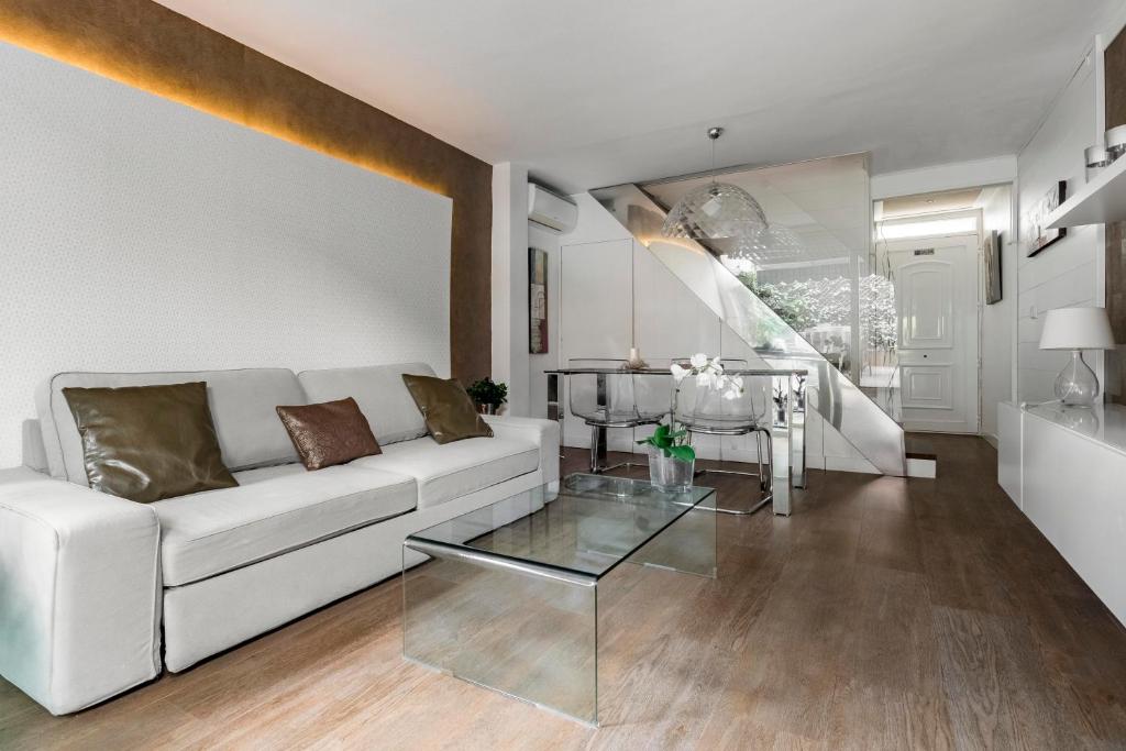 马德里Chalet independiente de diseño con Patio Privado的客厅配有白色沙发和玻璃桌
