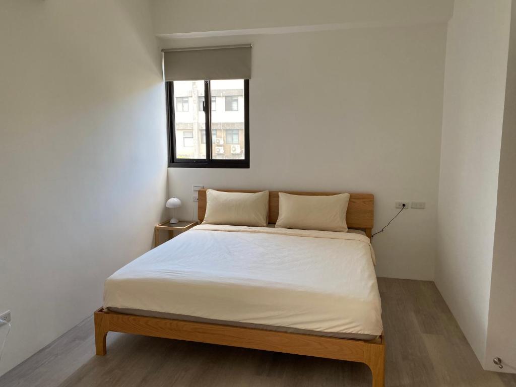 三星乡微困旅宿的一间卧室配有一张带白色床单的床和一扇窗户。