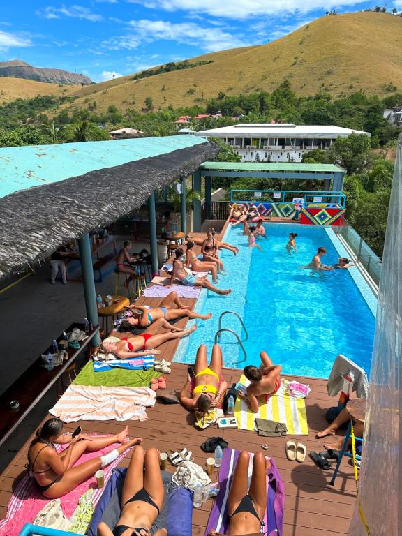 科隆Outpost Hostel - Coron的一群人躺在游泳池的毛巾上