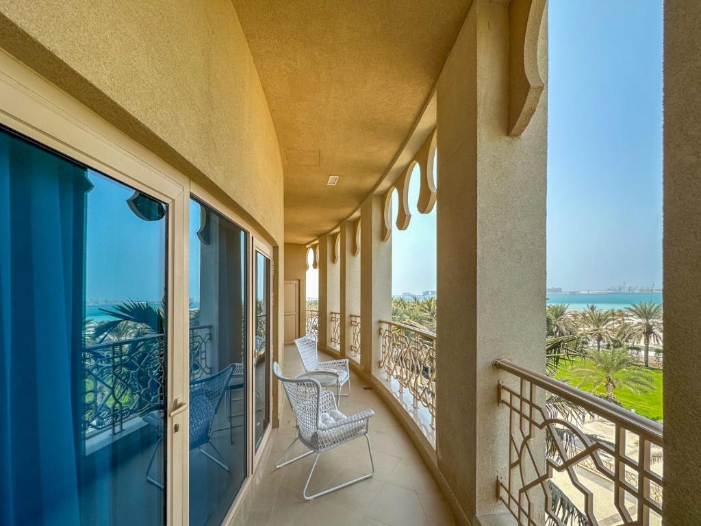 拉斯阿尔卡麦I Like Al Hamra Palace - Elite Beach & Golf Resort Private Suites的阳台配有两把椅子,享有海景。