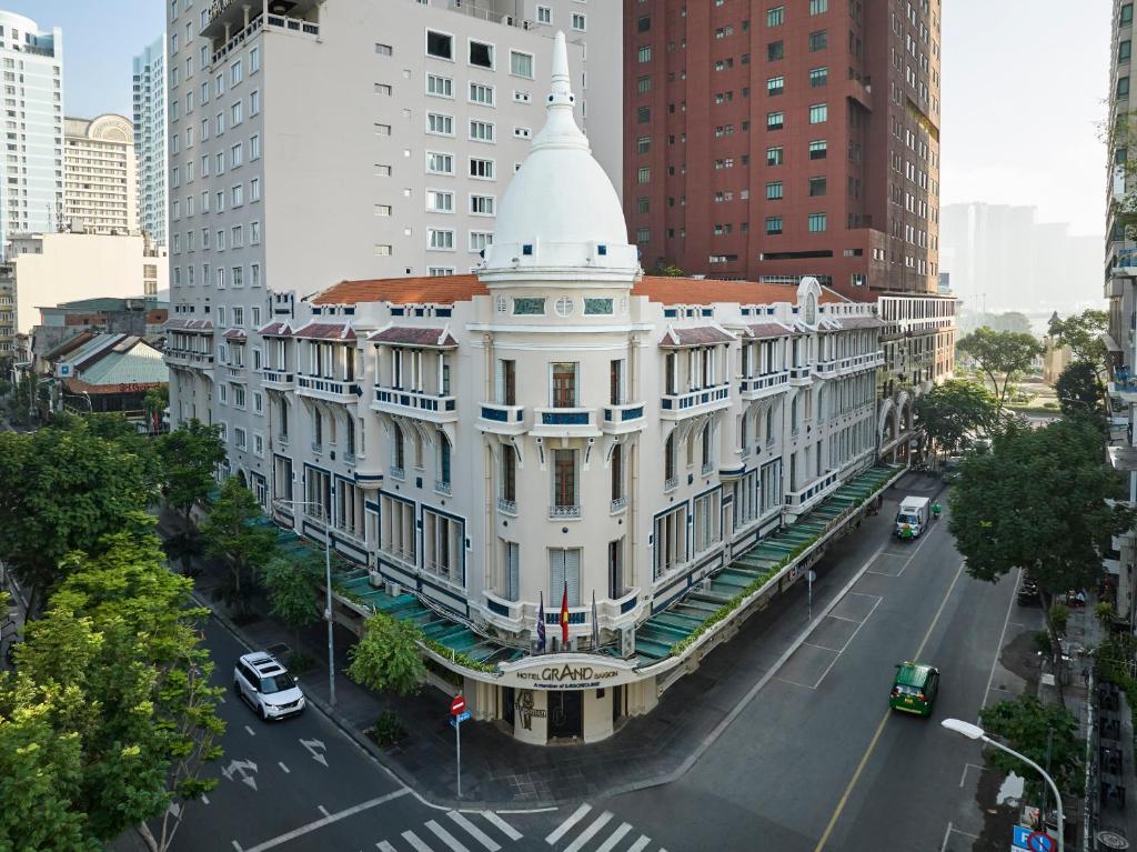 胡志明市Hotel Grand Saigon的一座白色的大建筑,城市里白色陡峭
