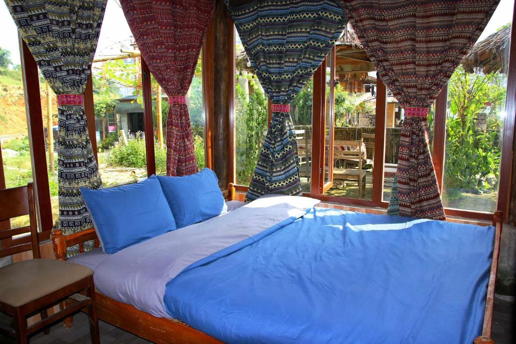 萨帕Traditional Wooden house & trekking adventure的窗帘和窗户的客房内的一张床位