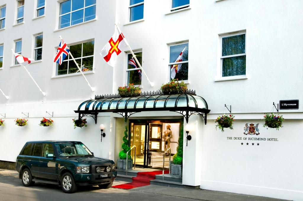 圣彼得港列治文公爵酒店的挂着英国国旗的建筑物外的汽车