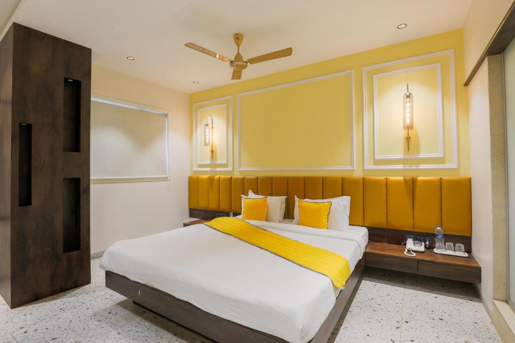 孟买The Cattleya Hotel - Near Marol, Andheri East, Mumbai的一间卧室配有一张带黄色床头板的大床