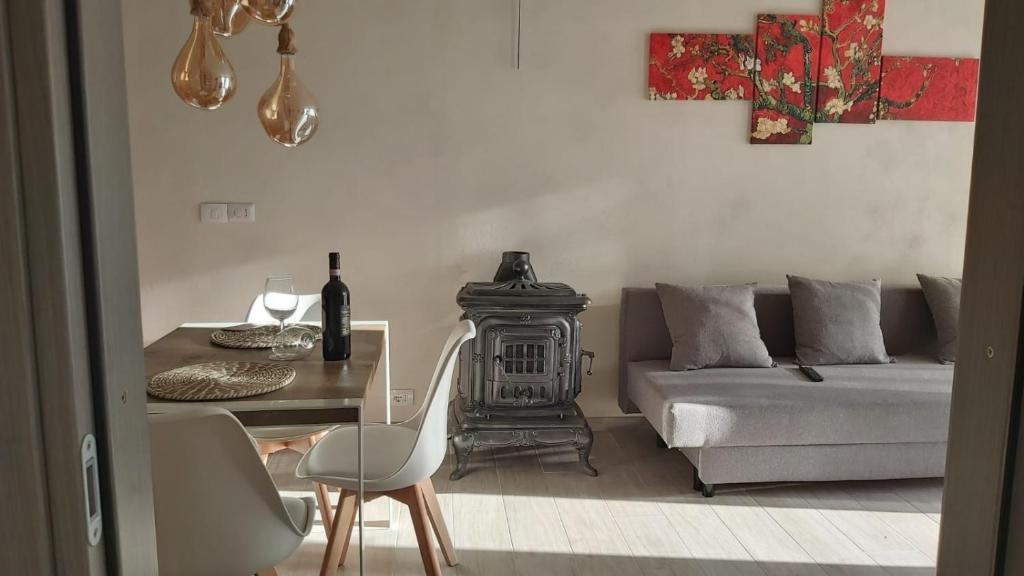 蒙特里久尼La Limonaia Country House的客厅配有沙发和带炉灶的桌子