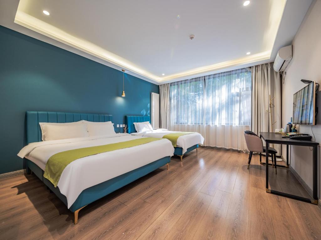 西安梧桐ins宿设计师酒店的酒店客房配有两张床和一张书桌
