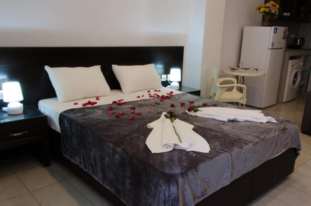 斯基亚索斯镇珀丽卡提斯旅馆的一间卧室,床上有红色玫瑰
