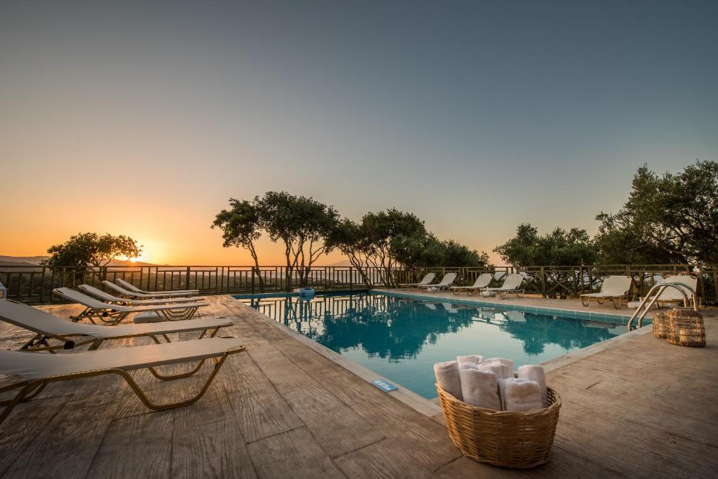 查加基恩乐福索利斯公寓式酒店的一个带椅子的游泳池,享有日落美景