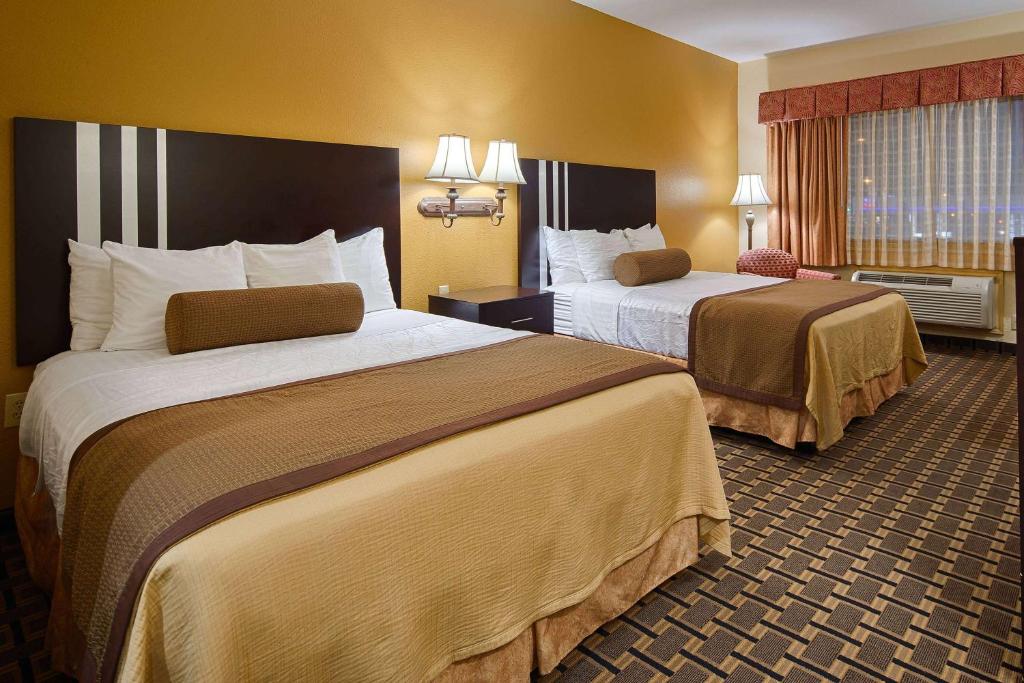 休斯顿Days Inn & Suites by Wyndham Sam Houston Tollway的一间酒店客房,房间内设有两张床