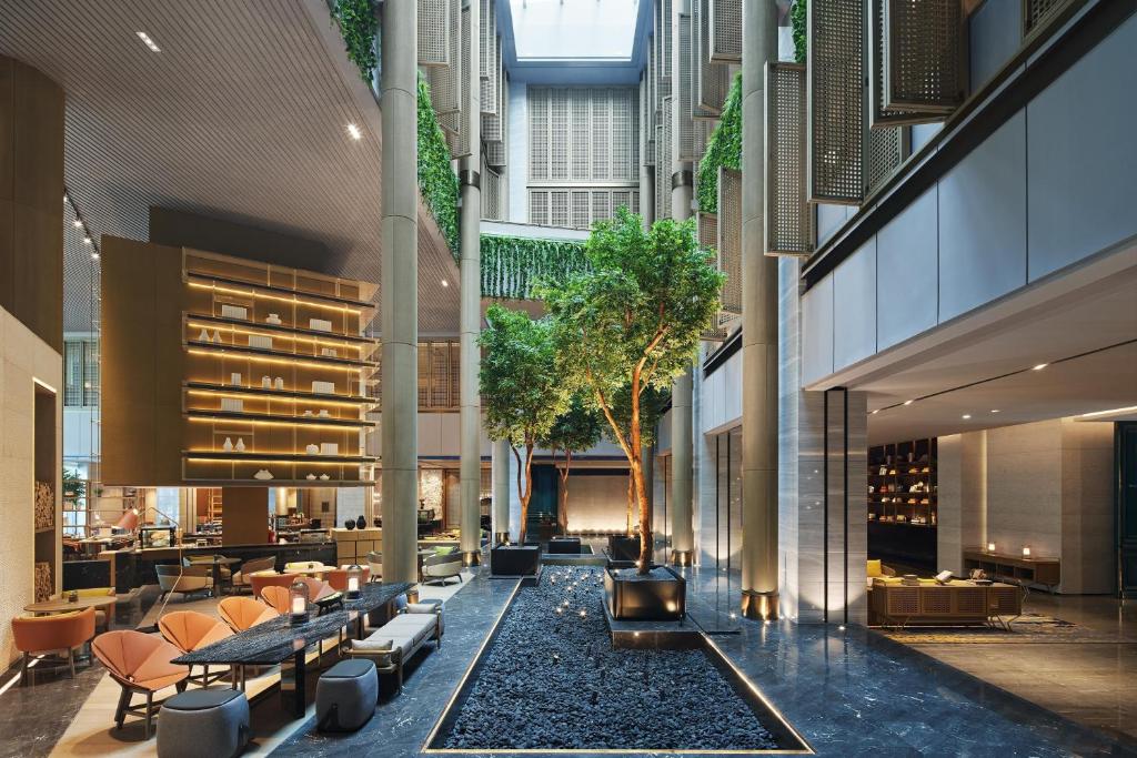深圳深圳博林天瑞喜来登酒店的一座带桌椅的建筑的内部庭院