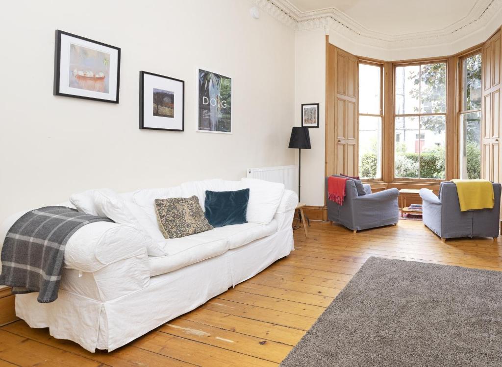 爱丁堡ALTIDO 3-bed Meadows flat near Castle的客厅配有白色沙发和两把椅子