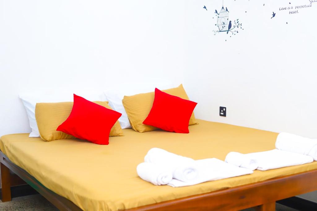 尼甘布Royal Hub的一张带红色和白色枕头的床