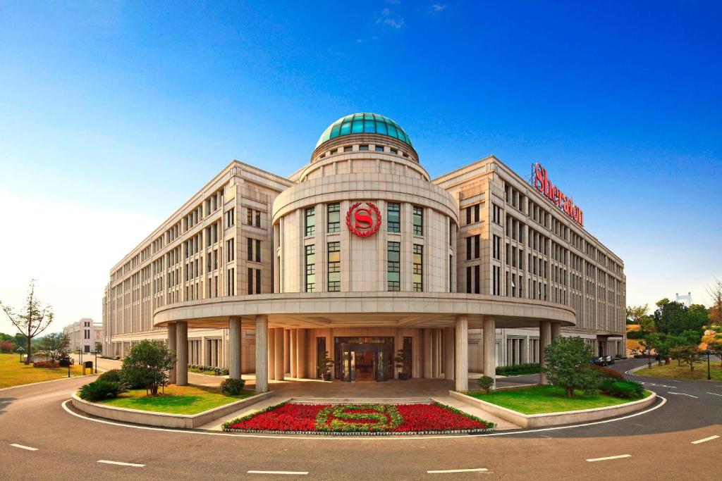 江阴江阴黄嘉喜来登酒店的一座白色的大建筑,上面有红色的标志