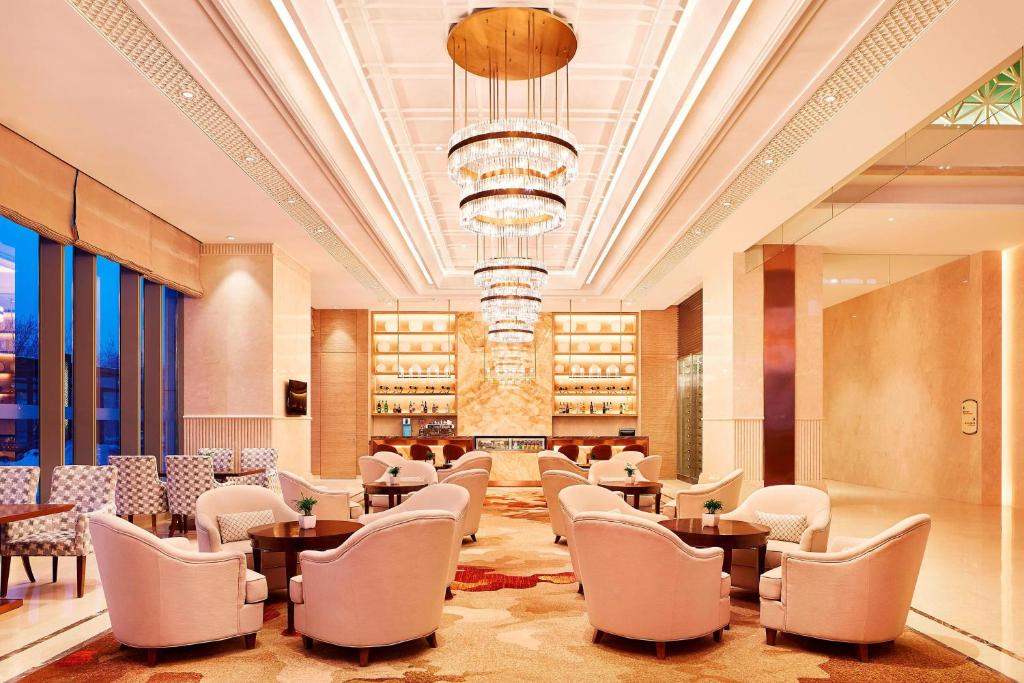 哈尔滨哈尔滨香坊永泰喜来登酒店的一间带桌椅和吊灯的餐厅