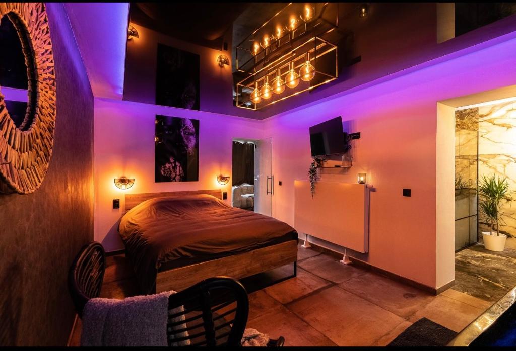 韦尔维耶La suite M的一间紫色灯卧室和一张位于客房内的床