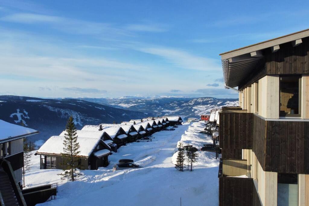 哈山Hafjell - Penthouse - ski in/out的享有积雪覆盖的街道和建筑的景色