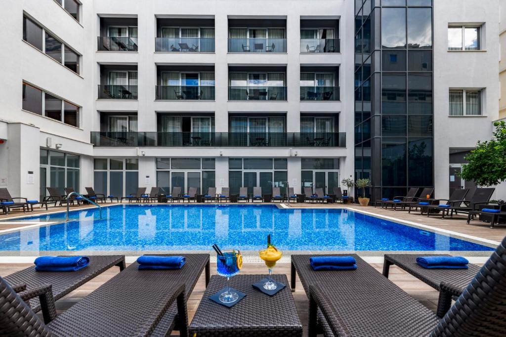 杜布罗夫尼克莱拉酒店的一座带椅子的游泳池以及一座建筑
