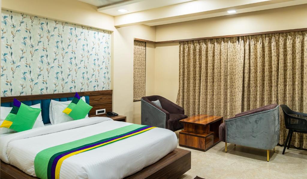 浦那Treebo Trend Lemon Wood Suites的配有一张床和一把椅子的酒店客房