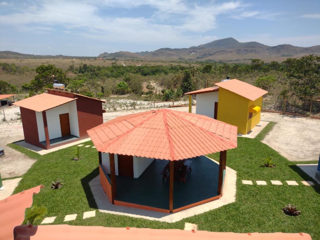 戈亚斯州上帕莱索Pousada Chalés Além do Paraíso的享有带雨伞的房子的顶部景色