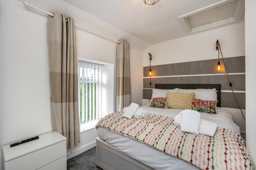 PontardaweThe New Lodge - Cottage - Tv in every bedroom!的一间卧室设有一张大床和一个窗户。