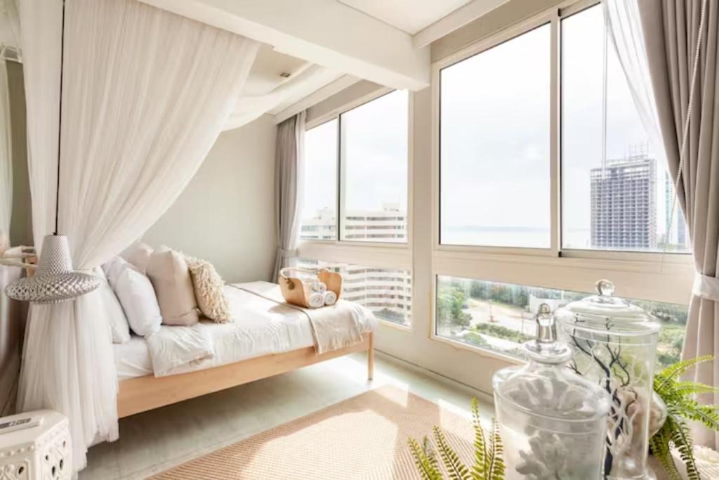 纳仲天Family Suite Sea view 2Bedroom at Veranda Residence Pattaya的一间卧室设有一张床和一个大窗户