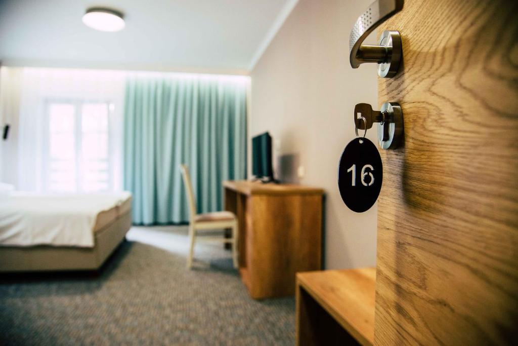KamieńskWrzosowa的酒店客房设有一间带一张床和一扇门的卧室