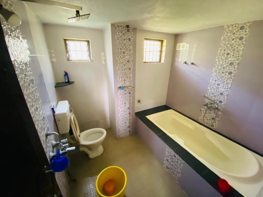 MādangeriGokarna cross stay的带浴缸、卫生间和盥洗盆的浴室