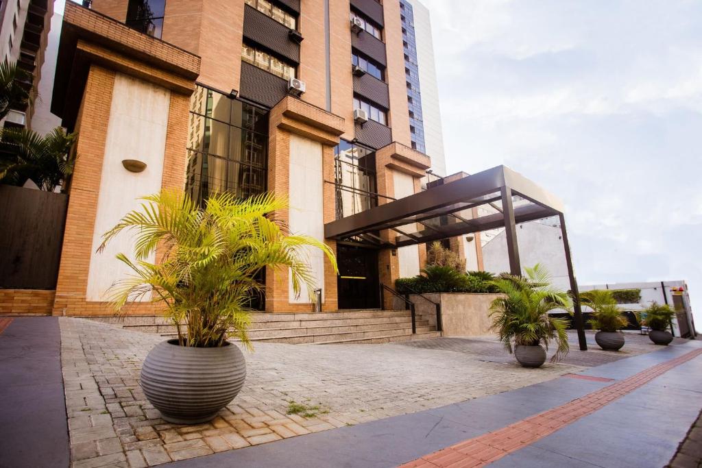 圣保罗LFlats no Hotel Hampton Park Jardim Paulista的前面有盆栽植物的建筑