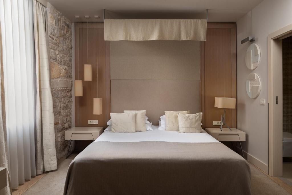 扎达尔卡勒拉贾艺术酒店的卧室配有一张带白色床单和枕头的大床。