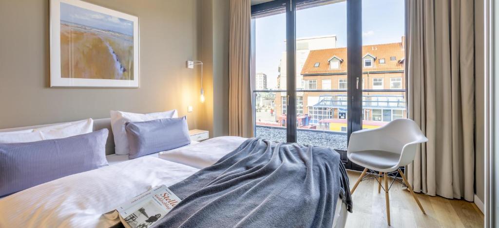 博尔库姆Sparkassengebäude Wohnung 2的卧室配有床、椅子和窗户。