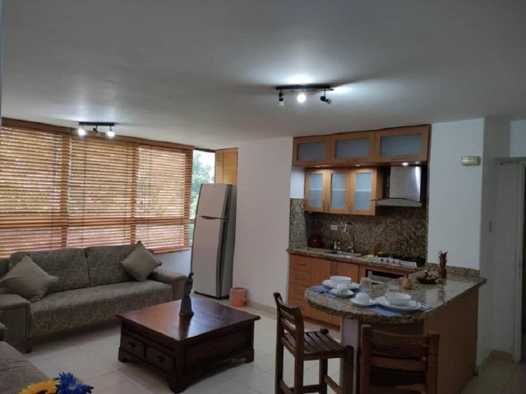 加拉加斯apartosuite Sabana Grande的厨房以及带沙发和桌子的客厅。