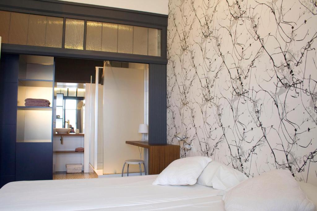 赫罗纳韦尔索菲西斯住宿加早餐酒店的一间卧室配有一张带白色床单和墙壁的床。