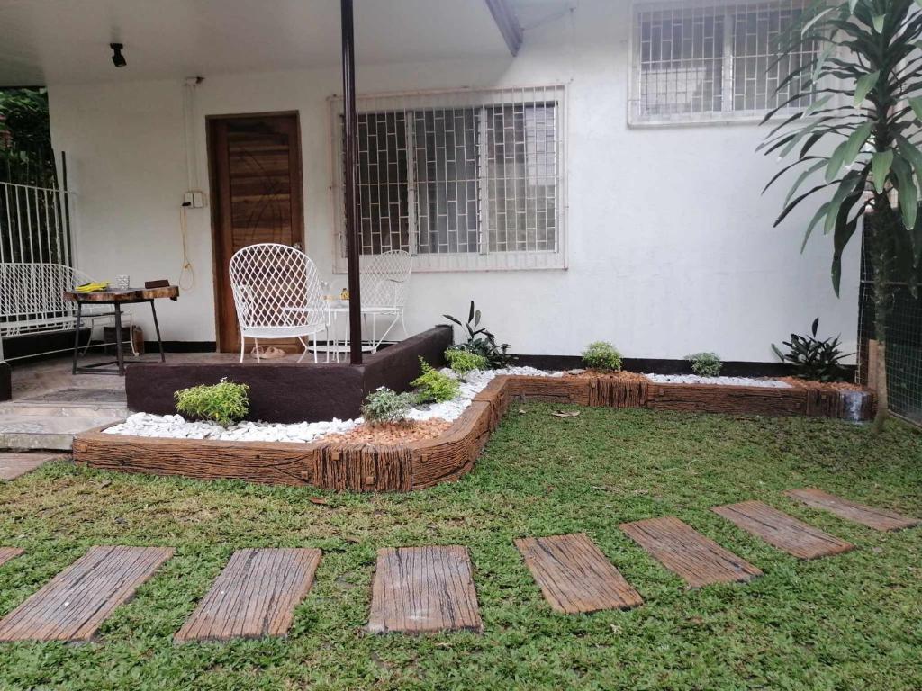巴科洛德FAST Wifi 400 Mbps Tiny House in Bacolod City的房屋前方设有木台阶的花园