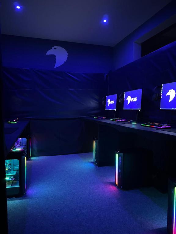 纳霍德FLY5 Gaming Spot的蓝色的房间,里面装有几台电脑显示器